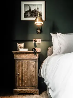 a bedroom with a bed and a table with a lamp at 1898 The Post in Ghent