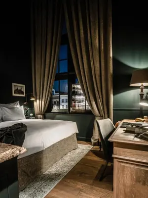 a bedroom with a bed and a desk and a window at 1898 The Post in Ghent