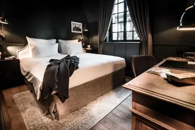 a hotel room with a bed and a desk and a desk at 1898 The Post in Ghent