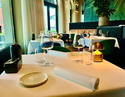 a table in a restaurant with wine glasses on it at U Eat & Sleep Antwerp in Antwerp