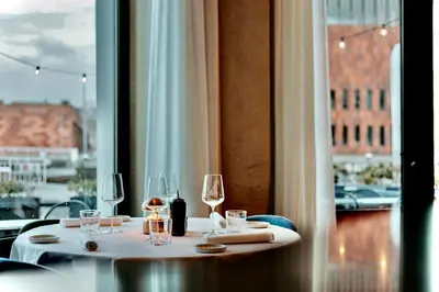 a table with wine glasses on it with a window at U Eat & Sleep Antwerp in Antwerp