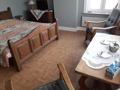 a bedroom with a bed and a table and chairs at B&B Mussenzele in Haaltert