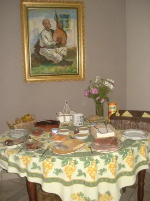 a table with plates of food on it with a painting at B&B Mussenzele in Haaltert