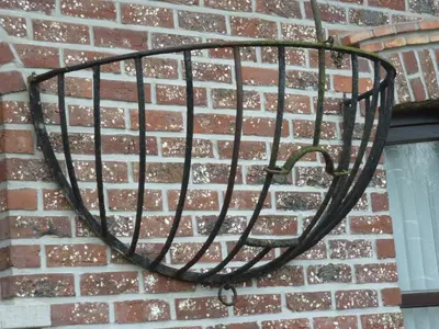 a metal basket hanging on a brick wall at B&B Mussenzele in Haaltert
