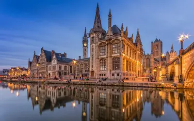 an old building next to a river at night at Lord of Ghent in Ghent