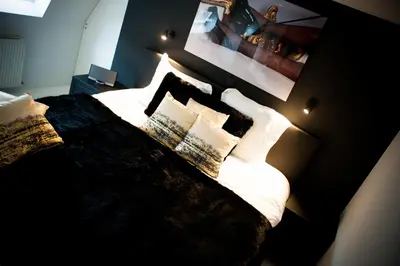 a bedroom with a large bed with white sheets and pillows at Lord of Ghent in Ghent