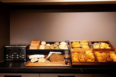 a bunch of different types of bread on a counter at Pillows City Hotel Brussels Centre in Brussels