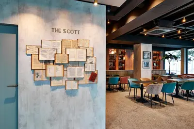 a wall in a restaurant with tables and chairs at The Scott Hotel Brussels in Brussels