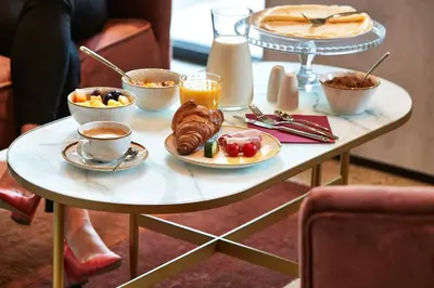 a table with breakfast foods and coffee on it at The Scott Hotel Brussels in Brussels