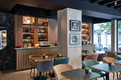 a restaurant with tables and chairs in a room at The Scott Hotel Brussels in Brussels