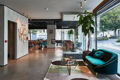 a living room with a blue couch and a table at The Scott Hotel Brussels in Brussels