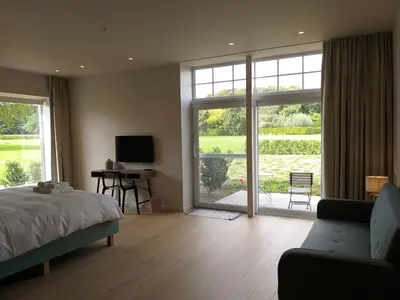 a bedroom with a bed and a sliding glass door at Hotel B - Boskapelhoeve in Buggenhout