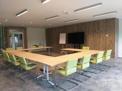 a conference room with a large wooden table and chairs at Hotel B - Boskapelhoeve in Buggenhout