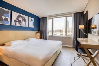 a hotel room with a large bed and a desk at Park Inn by Radisson Antwerp City Centre in Antwerp