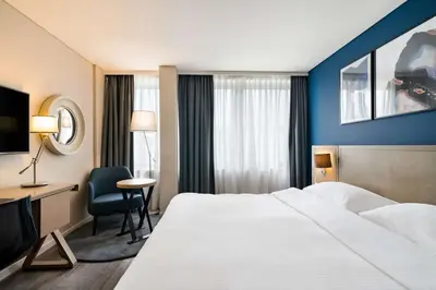 a hotel room with a large bed and a desk at Park Inn by Radisson Antwerp City Centre in Antwerp