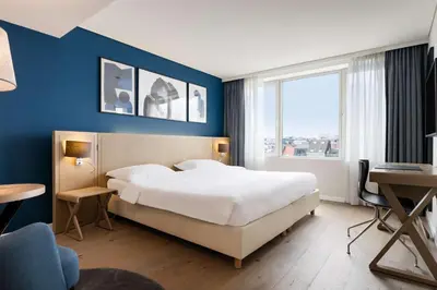 a bedroom with a large bed and a blue wall at Park Inn by Radisson Antwerp City Centre in Antwerp