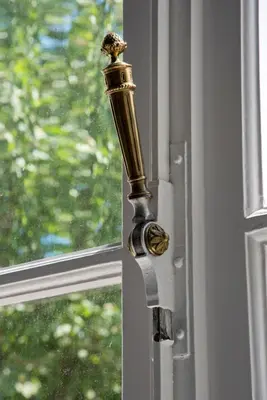 a gold door knob on a window with a window at Appartement Chic in Brussels