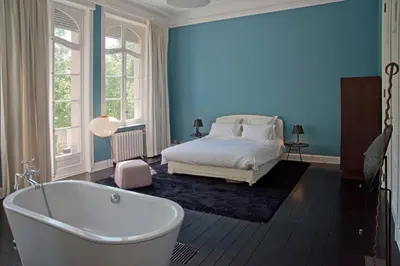 a bedroom with a bed and a tub in it at Appartement Chic in Brussels