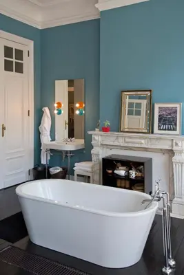 a white bath tub in a room with a fireplace at Appartement Chic in Brussels