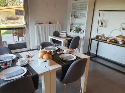 a dining room with a table and chairs with food on it at B&B 't Hoogste in Bornem