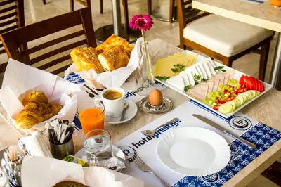 a table with a breakfast of bread and food at Hotel Prestige in Brussels