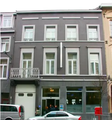 a large building with cars parked in front of it at Hotel Prestige in Brussels