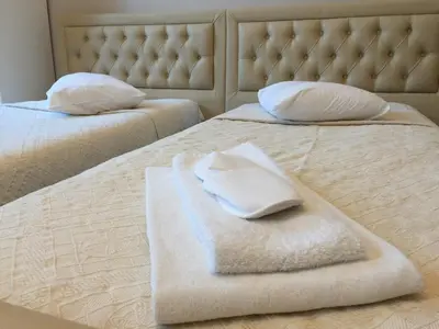 two beds with white towels on top of them at Hotel Prestige in Brussels
