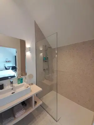 a bathroom with a sink and a shower with a mirror at B&B De Stuifduinen in Wetteren