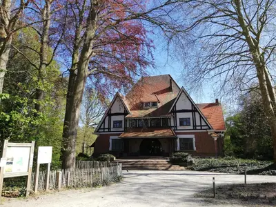 a large house with a fence in front of it at B&B De Stuifduinen in Wetteren
