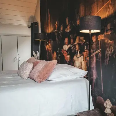 a bedroom with a bed with a painting on the wall at B&B Bergenhof in Hoogstraten
