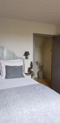a bedroom with a large white bed and a lamp at B&B Bergenhof in Hoogstraten