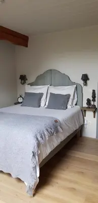 a bedroom with a large bed with white sheets and pillows at B&B Bergenhof in Hoogstraten
