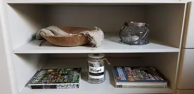 a shelf with books and a bowl and a jar at B&B Bergenhof in Hoogstraten