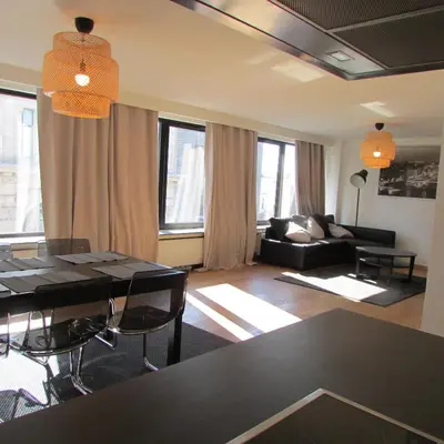 a living room with a table and a couch at Huidreal Meir in Antwerp