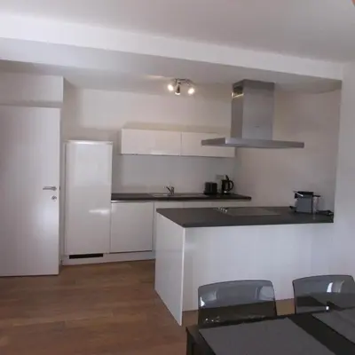 a kitchen with white cabinets and a white refrigerator at Huidreal Meir in Antwerp