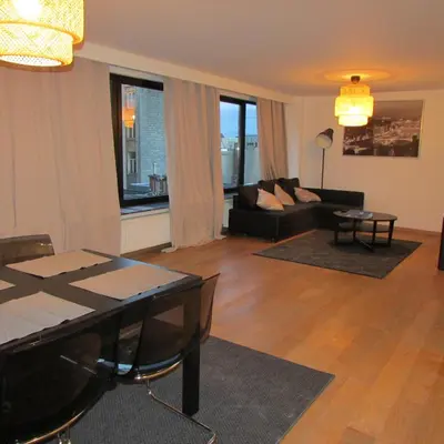 a living room with a couch and a table at Huidreal Meir in Antwerp