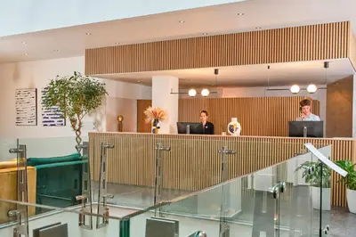 two people sitting at desks in an office at Hôtel Aqua by HappyCulture in Brussels