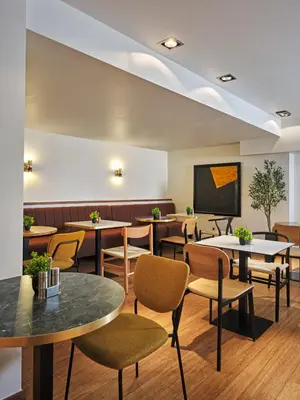 a waiting room with tables and chairs and a chalkboard at Hôtel Aqua by HappyCulture in Brussels