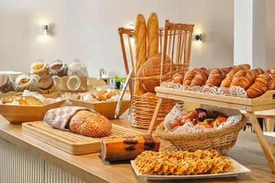 a table with various types of bread and pastries at Hôtel Aqua by HappyCulture in Brussels