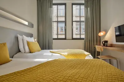 a hotel room with two beds and a window at Hôtel Aqua by HappyCulture in Brussels