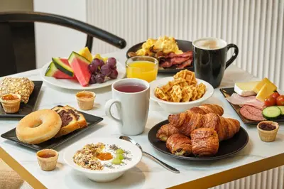 a table topped with plates of breakfast foods and coffee at Hôtel Aqua by HappyCulture in Brussels