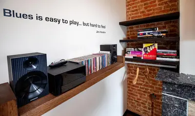 a wall with a book shelf with dvds at Rock Lobster City Lodge in Antwerp