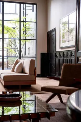 a living room with a couch and large windows at Hotel Julien in Antwerp