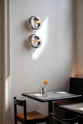 a table with two lights on a white wall at Hotel Julien in Antwerp