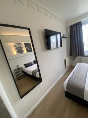 a mirror in a hotel room with two beds at Beaux ARTS in Antwerp