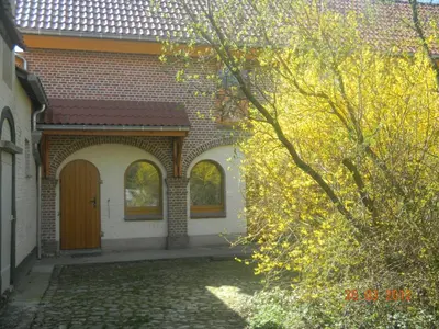 a brick house with a brown door and a tree at Verreveld in Londerzeel