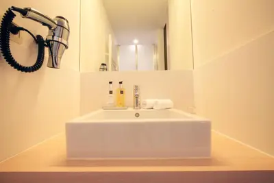 a white sink in a bathroom with a mirror at Antwerp For Two B&B in Antwerp