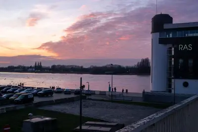 a body of water with boats parked next to a building at Antwerp For Two B&B in Antwerp