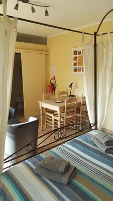 a bedroom with a bed and a dining room at B&B La Clé du Sud in Merelbeke