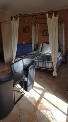 a room with two beds and a chair and a bed at B&B La Clé du Sud in Merelbeke